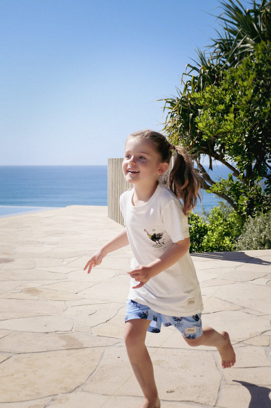 Front of NL Kids Scrub Club Tee – White worn running beside the pool at Domic, Sunshine Beach
