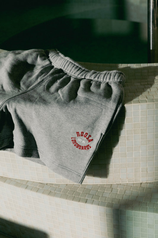 NL Established Track Shorts Grey Marle folded on the curved tiled bench at Domic