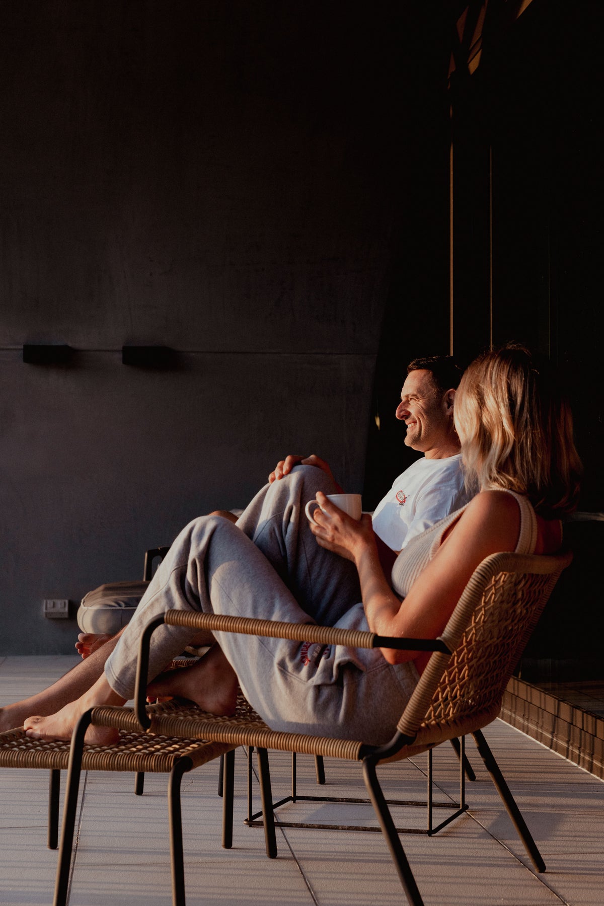 NL Established Womens Track Pants Grey Marle worn seated in a lounge chair at Domic, Sunshine Beach