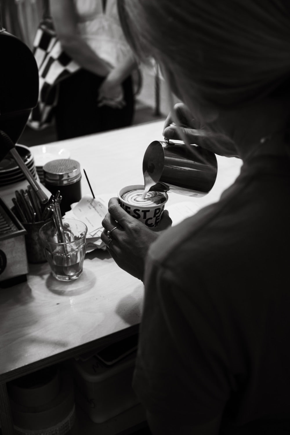 A barista pouring milk into a coffee at Noosa Longboards