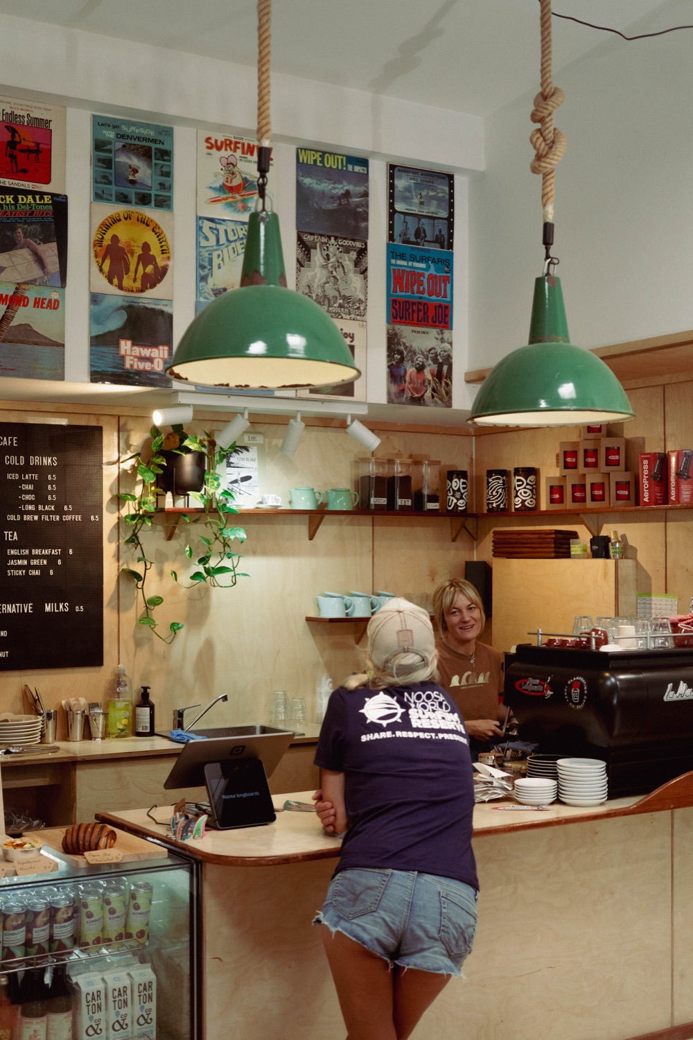 Customers and staff at the Noosa Records and Espresso coffee bar, beneath green pendant lights